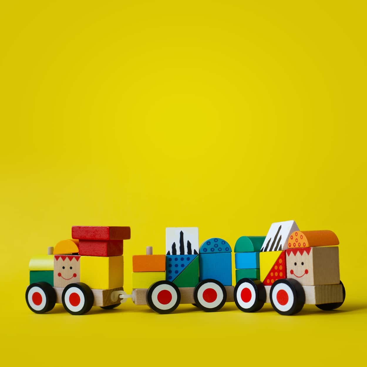 Colorful wooden train on wheels. Sorter type of blocks for early child development. Eco friendly toy. Vivid and bright background with copy space.
