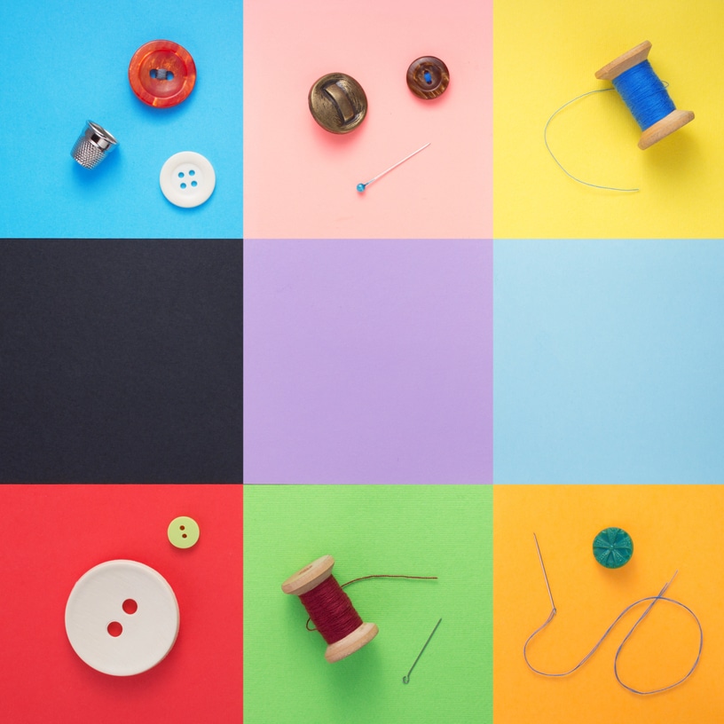 sewing tools and accessories at paper background texture, top view