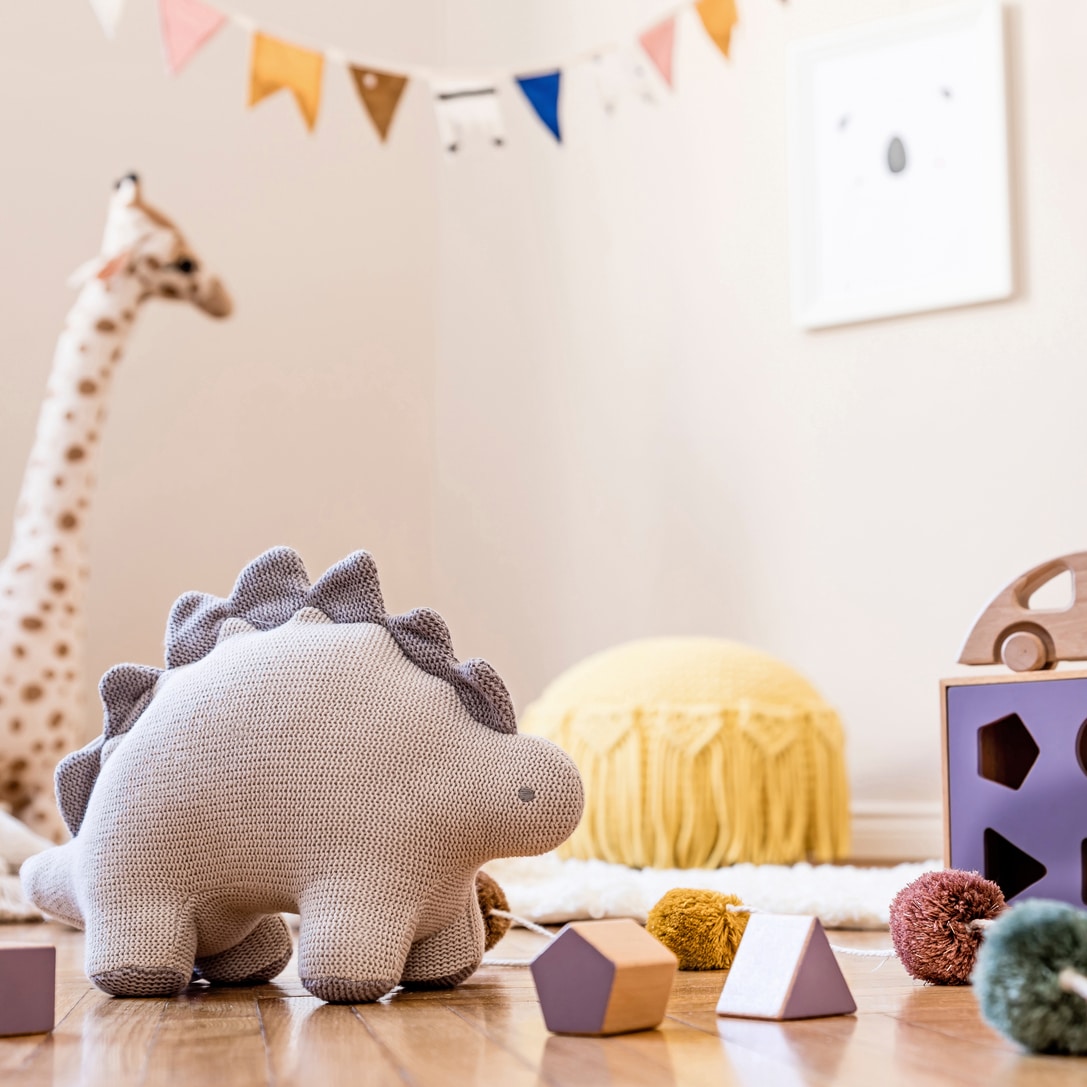 Stylish scandinavian interior of child room with mock up frame ,natural toys, hanging decoration, design furniture, plush animals, teddy bears and accessories. Interior design of kid room.