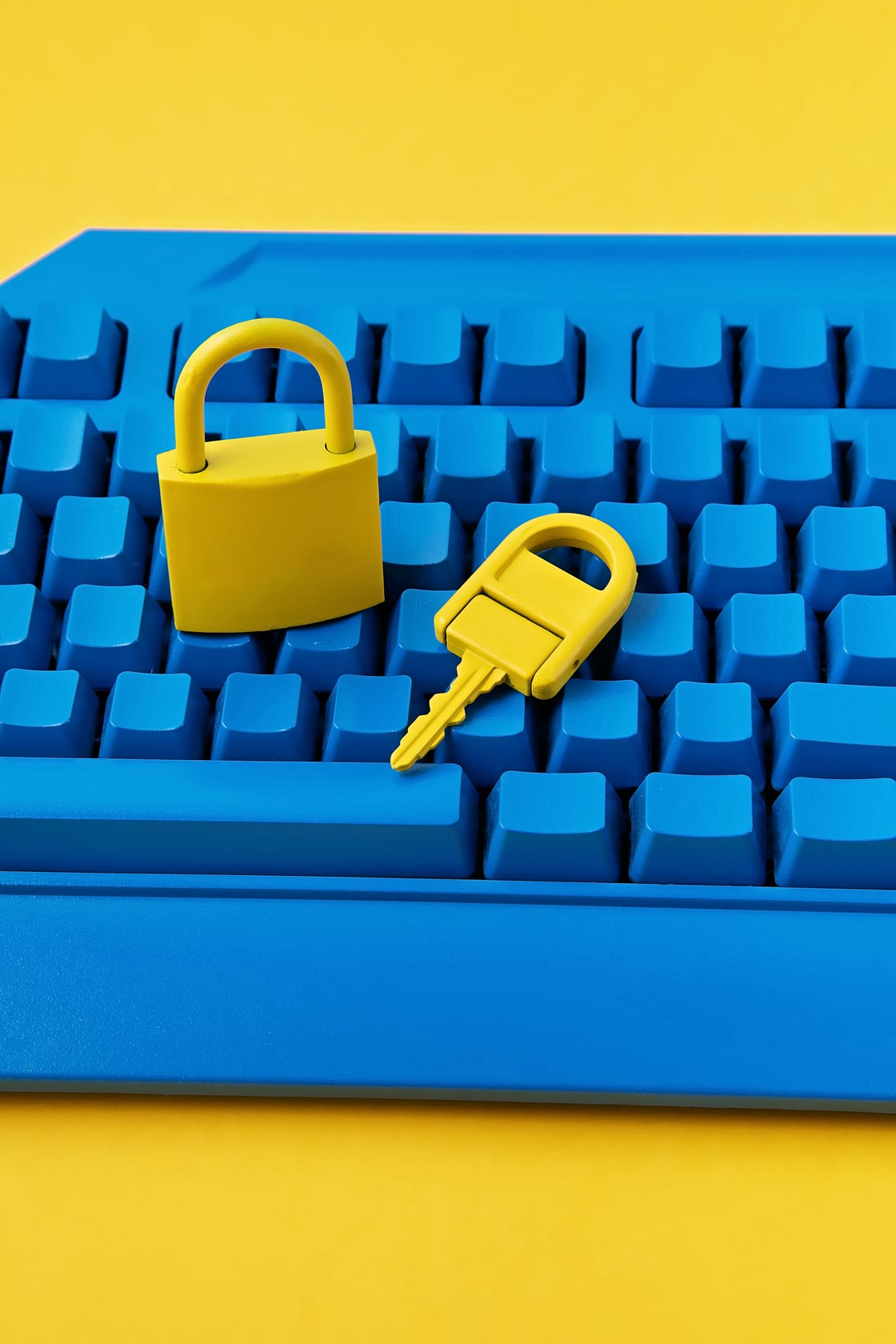 Cyber data and information security idea. Yellow padlock and key and blue keyboard. Computer, information safety, confidentiality concept.